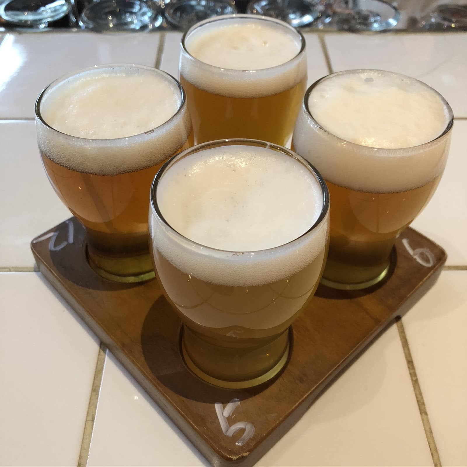 A flight of four tasting glasses of craft beer